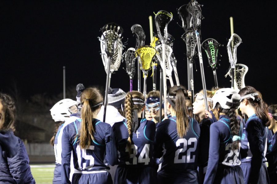 The girls lacrosse team huddles during their game against Corner Canyon. 