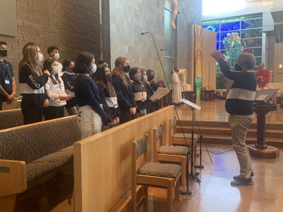 John VanWagoner directing the choir at the Junior Class Mass last Thursday.